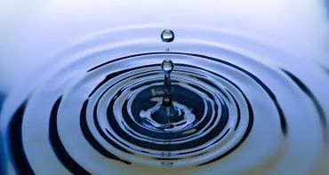 Symbolbild mit Wassertropfen auf Wasser treffend